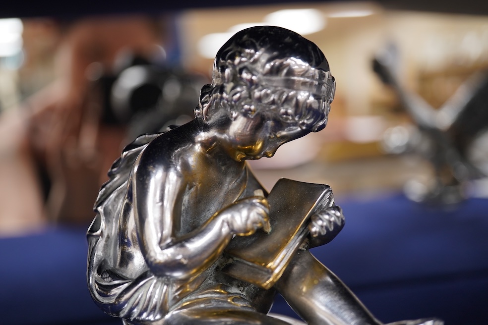 Two chrome car mascots, one in the form of an eagle stamped Finnigans London, wingspan 26cm, and the other of a classical child writing, mounted on a substantial radiator cap and oak base. Condition - fair to good, some